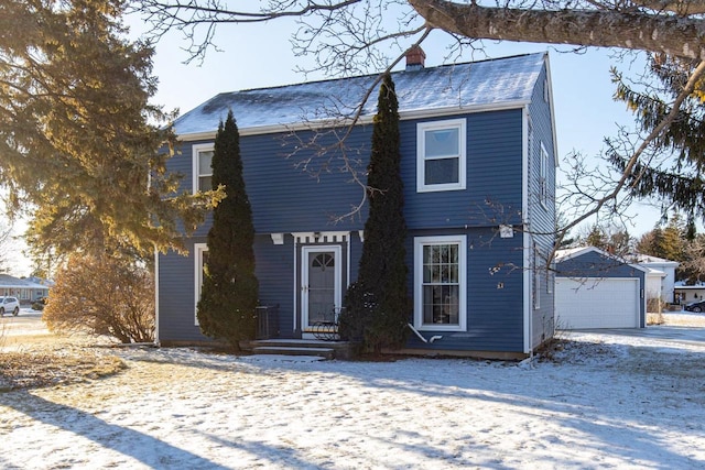 view of front of property featuring a garage and an outdoor structure