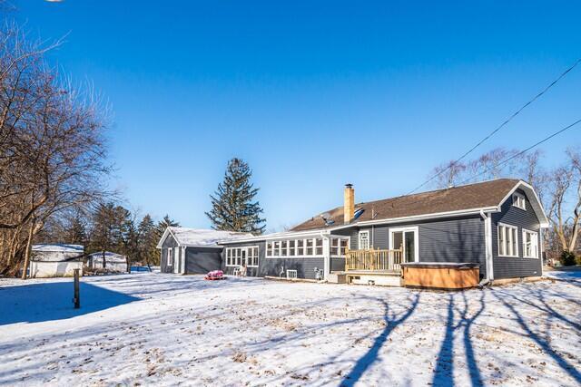 snow covered property with a hot tub