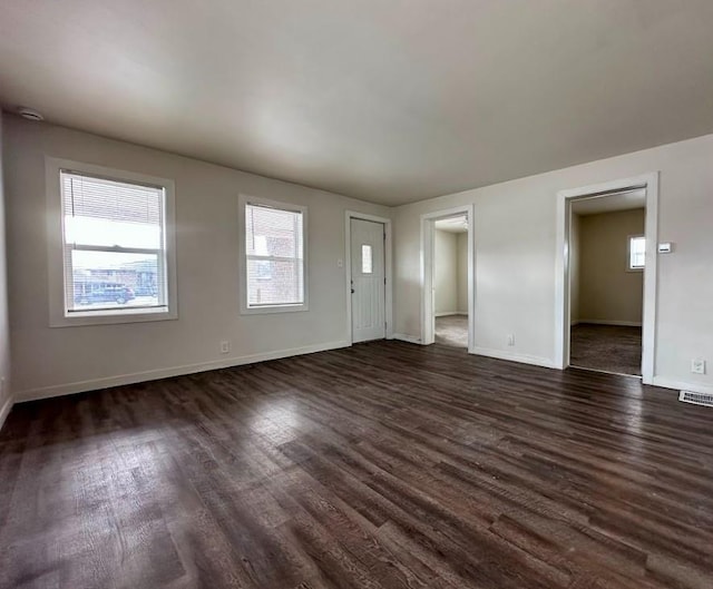 unfurnished living room with dark wood-type flooring