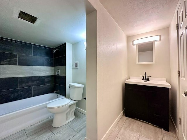 full bathroom featuring a textured ceiling, toilet, tiled shower / bath combo, and vanity