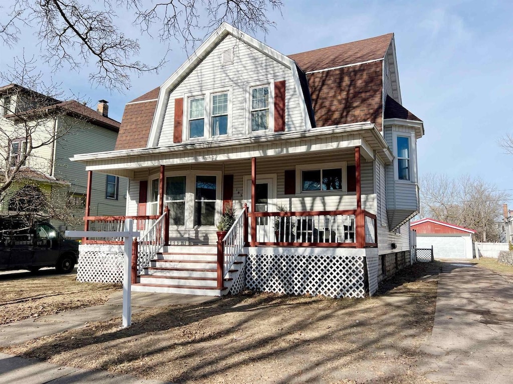 view of front of house with an outdoor structure, covered porch, and a garage