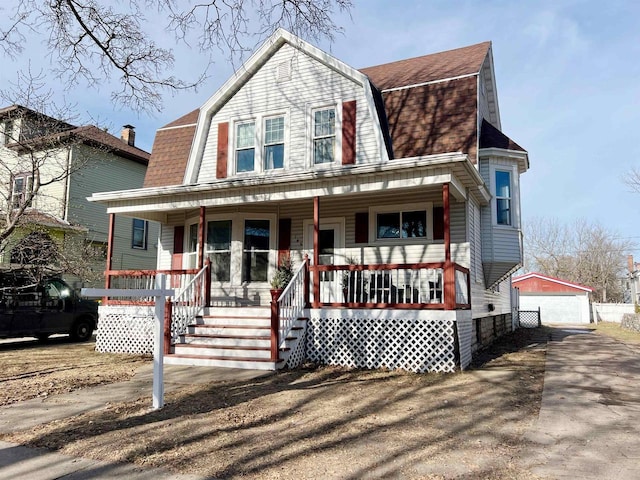 view of front of house with an outdoor structure, covered porch, and a garage