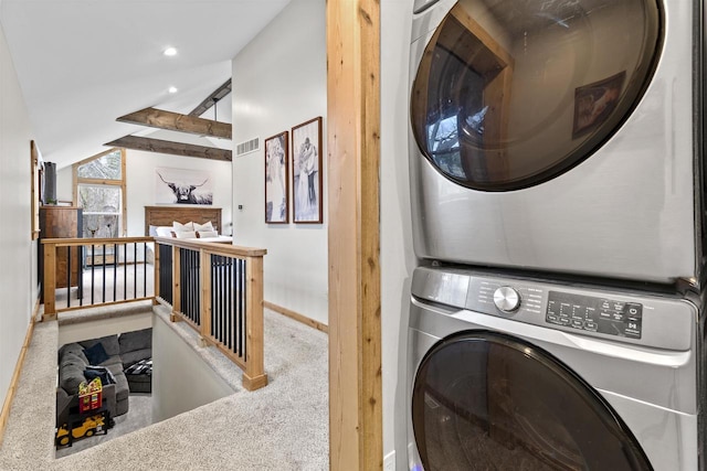 laundry room featuring carpet and stacked washer / drying machine