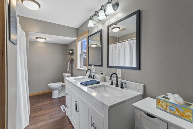 bathroom with toilet, hardwood / wood-style floors, and vanity