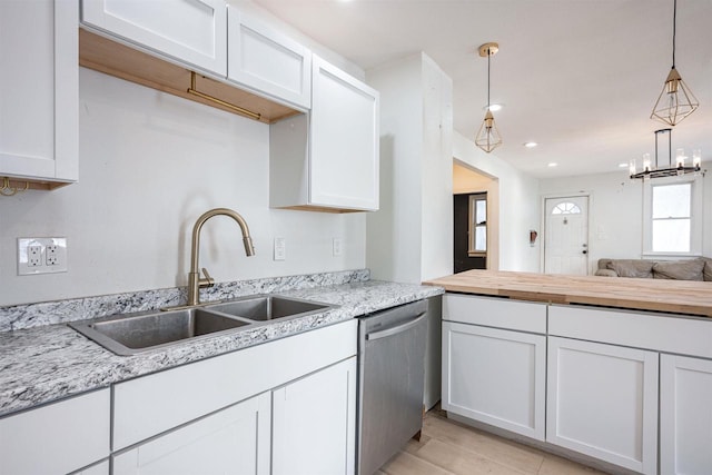 kitchen featuring pendant lighting, sink, white cabinetry, and dishwasher