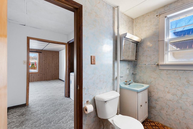 bathroom with toilet, washer / clothes dryer, a healthy amount of sunlight, and vanity