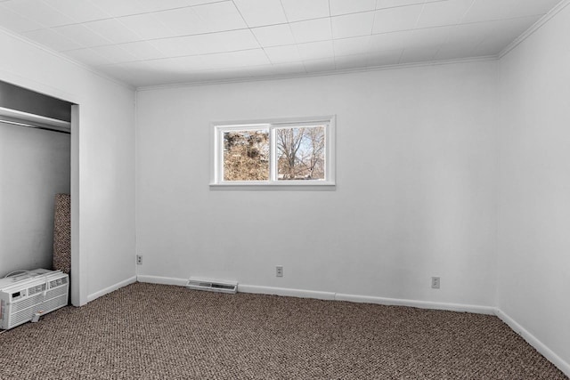 unfurnished bedroom with carpet, a closet, crown molding, and a wall mounted air conditioner