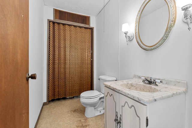 bathroom with toilet, vanity, and a textured ceiling