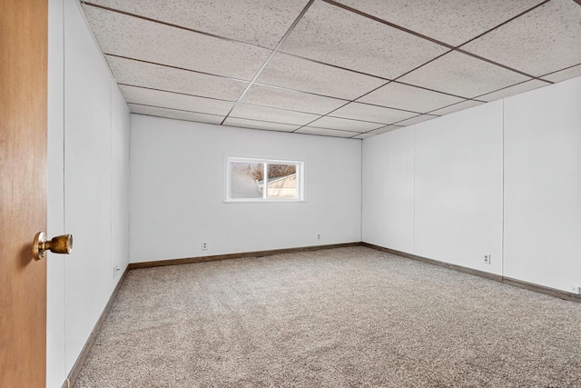 carpeted empty room with a paneled ceiling