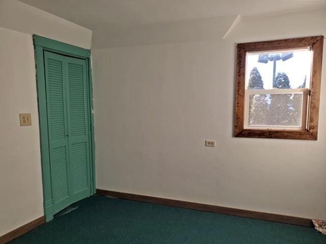 spare room featuring dark carpet