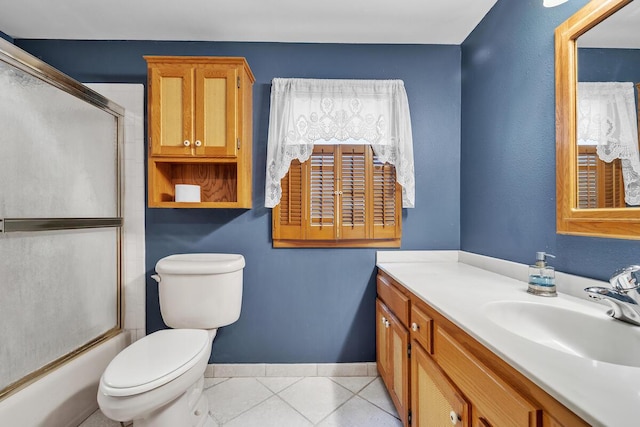 full bathroom featuring bath / shower combo with glass door, toilet, vanity, and tile patterned flooring