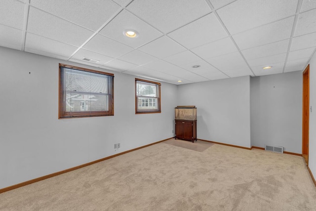 carpeted spare room with a paneled ceiling