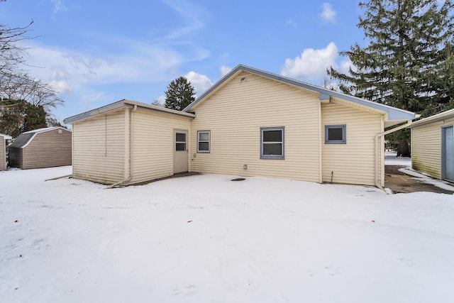 view of snow covered back of property