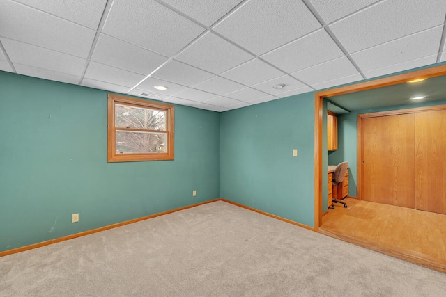 basement featuring carpet floors and a paneled ceiling