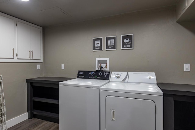 washroom featuring dark hardwood / wood-style floors, independent washer and dryer, and cabinets