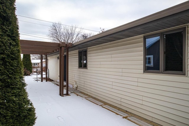 view of snowy exterior featuring a pergola