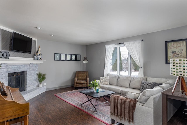 living room with dark wood-type flooring and a brick fireplace