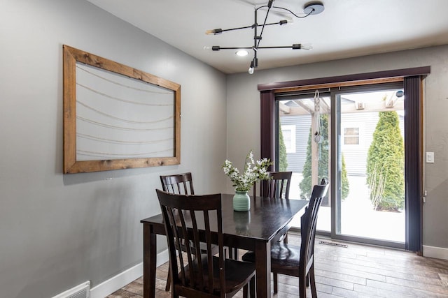 dining area with an inviting chandelier and light hardwood / wood-style floors