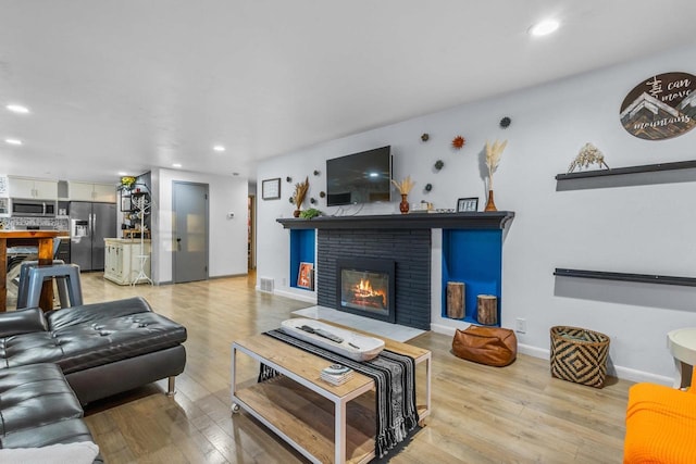 living room featuring a fireplace and light hardwood / wood-style flooring