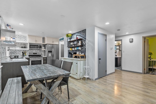 dining space with light hardwood / wood-style flooring and sink