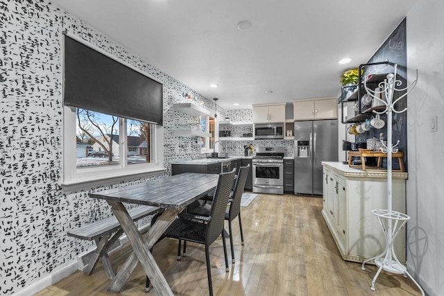 dining space with sink and light hardwood / wood-style floors