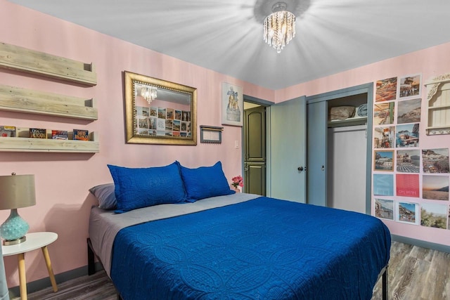 bedroom featuring hardwood / wood-style floors, a closet, and a chandelier