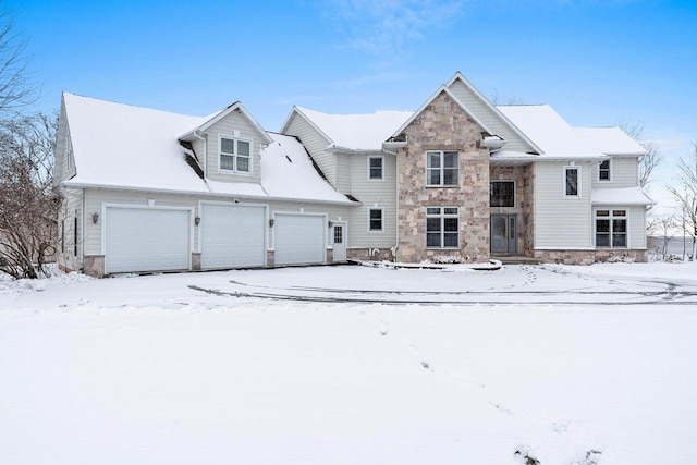 snow covered rear of property featuring a garage