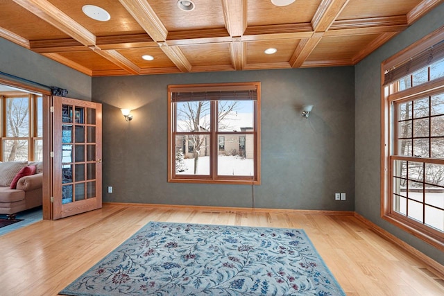 interior space featuring wooden ceiling, light hardwood / wood-style flooring, ornamental molding, and coffered ceiling