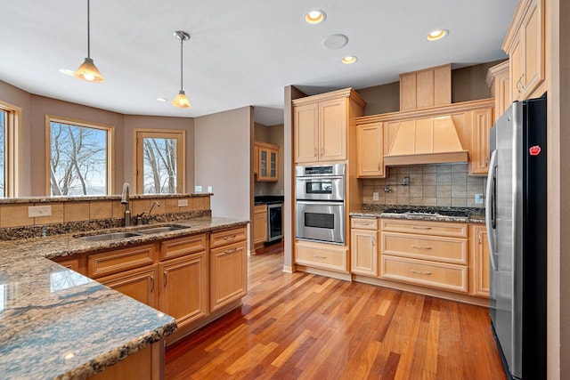 kitchen with decorative light fixtures, tasteful backsplash, dark stone countertops, sink, and appliances with stainless steel finishes