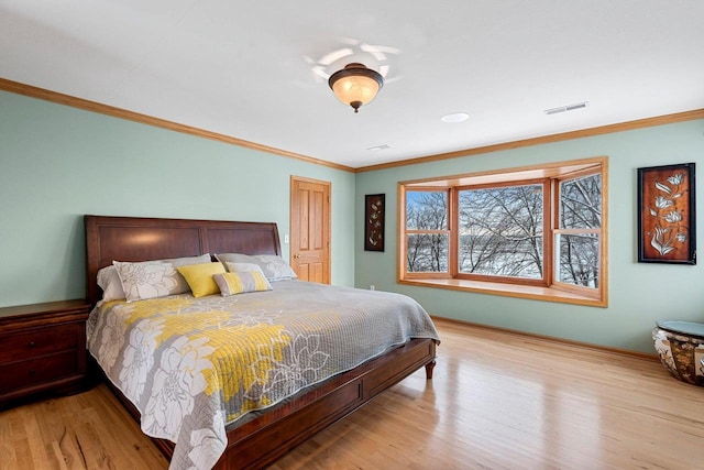 bedroom with crown molding and light hardwood / wood-style flooring