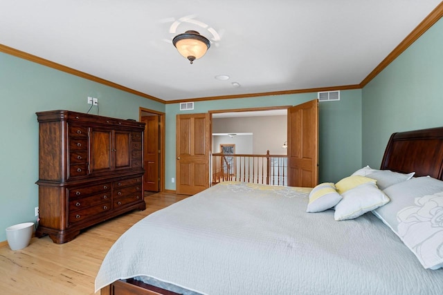 bedroom with light wood-type flooring and crown molding