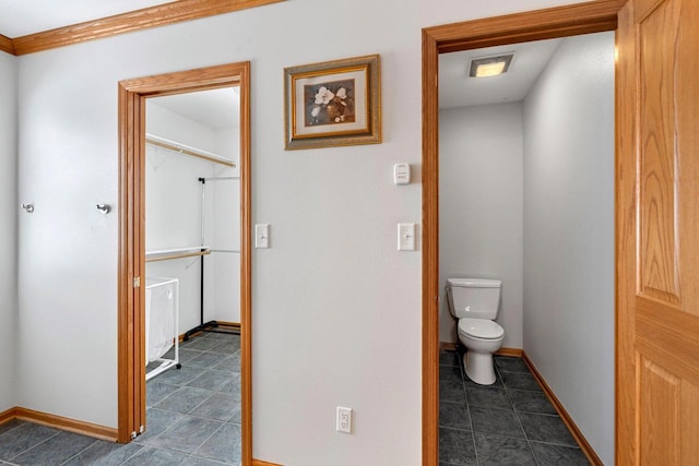 bathroom featuring toilet and crown molding