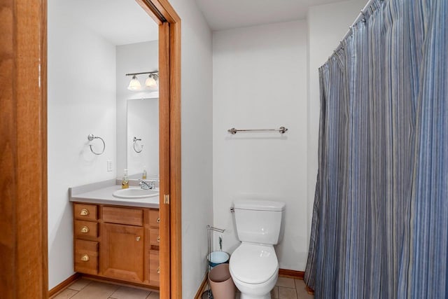 bathroom with toilet, vanity, and tile patterned flooring