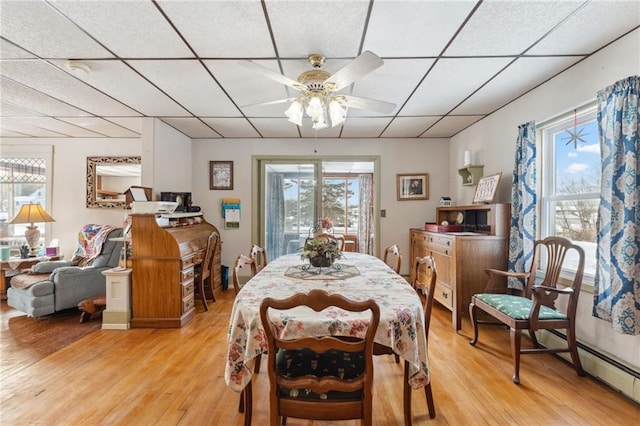 dining area featuring ceiling fan, a wealth of natural light, a baseboard radiator, and light hardwood / wood-style floors