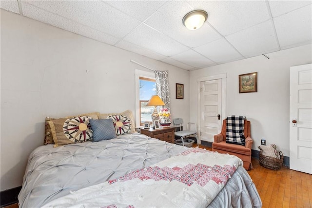 bedroom with hardwood / wood-style flooring and a drop ceiling