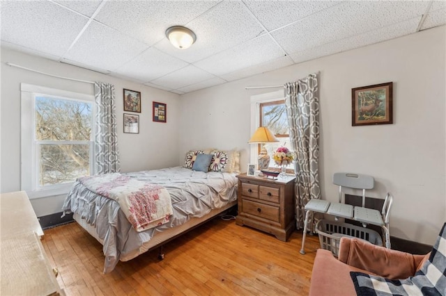 bedroom featuring light hardwood / wood-style floors and a drop ceiling