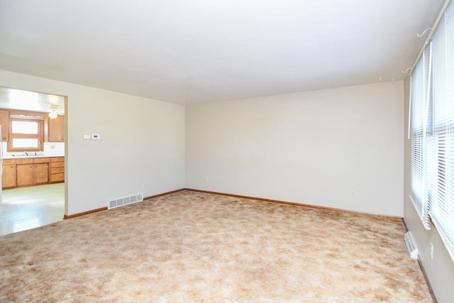 empty room featuring light carpet and sink