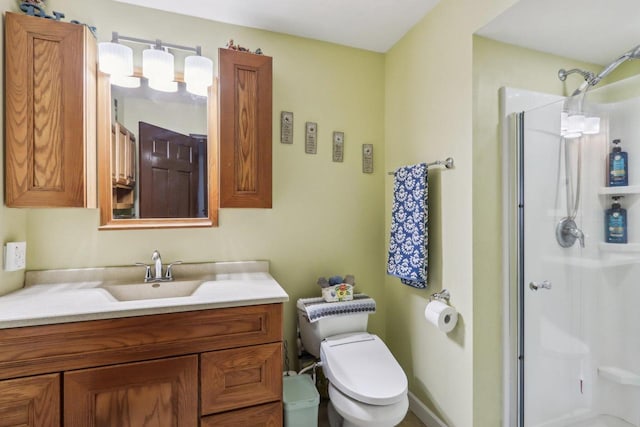 bathroom featuring toilet, a shower with shower door, and vanity