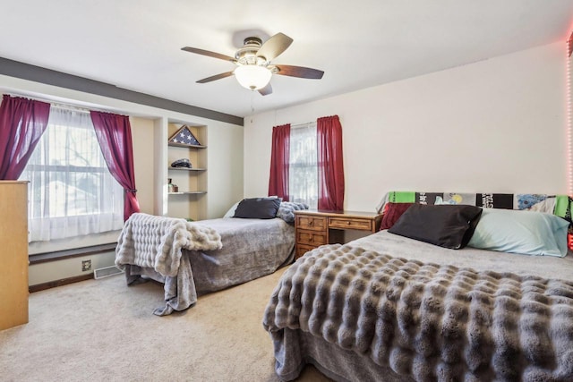 bedroom featuring ceiling fan, light colored carpet, and multiple windows