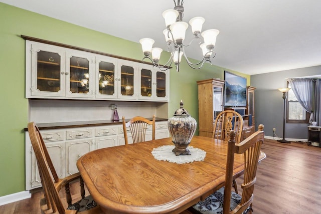 dining space with dark hardwood / wood-style flooring and an inviting chandelier