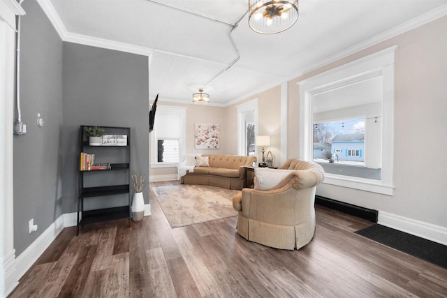 living room featuring a notable chandelier, ornamental molding, and hardwood / wood-style floors