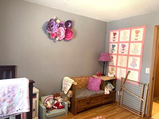 bedroom with a textured ceiling and wood-type flooring