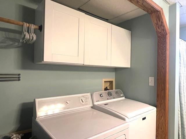 washroom with washing machine and clothes dryer and cabinets