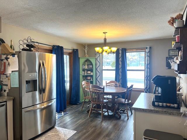 kitchen featuring stainless steel fridge, an inviting chandelier, a textured ceiling, and pendant lighting