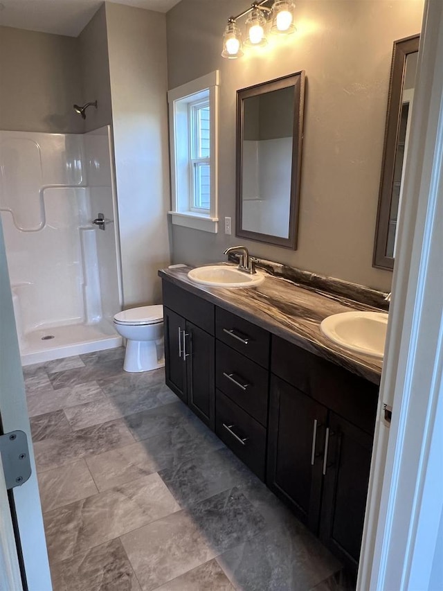 bathroom with toilet, vanity, and walk in shower