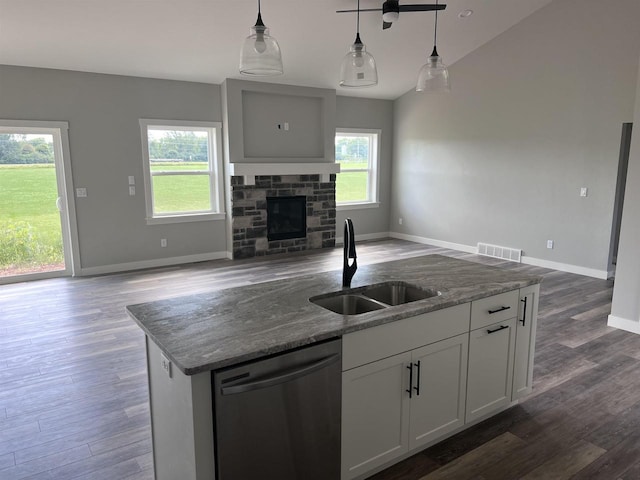 kitchen with dishwasher, a fireplace, sink, hanging light fixtures, and white cabinets