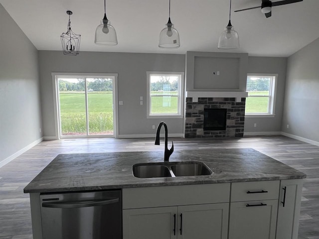 kitchen featuring decorative light fixtures, a fireplace, sink, ceiling fan, and stainless steel dishwasher