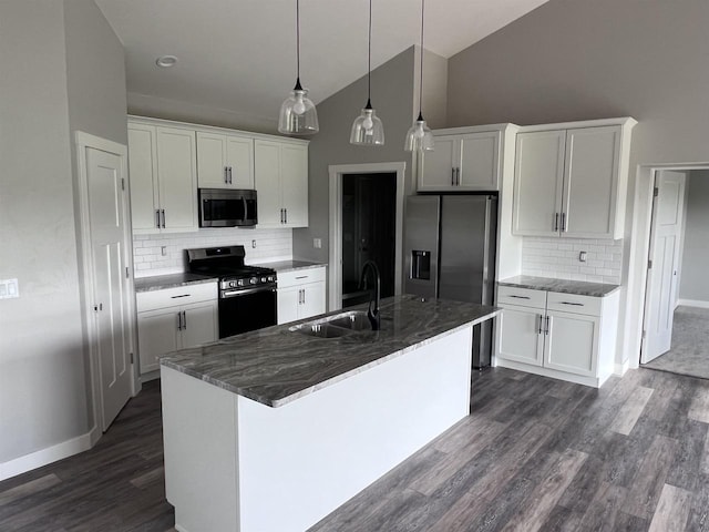 kitchen featuring tasteful backsplash, a center island with sink, sink, stainless steel appliances, and white cabinets