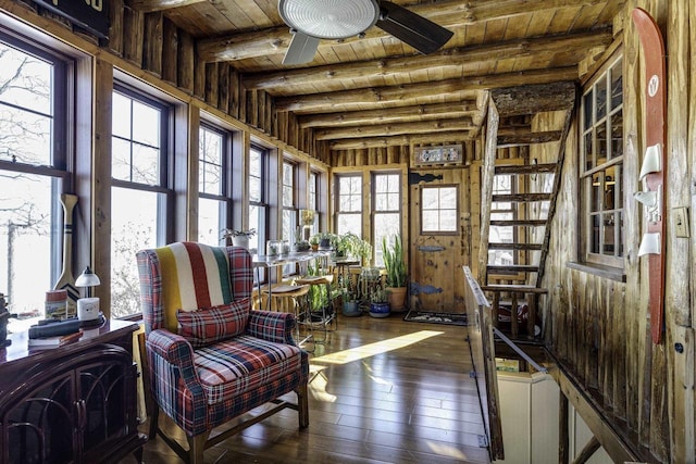 sunroom / solarium featuring ceiling fan, beam ceiling, and wooden ceiling