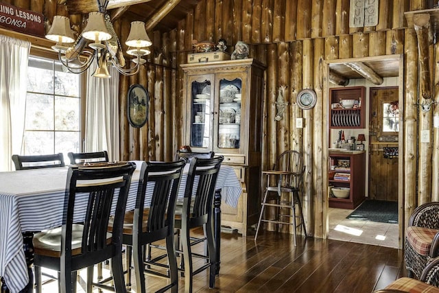 interior space featuring dark wood-type flooring, a chandelier, and wood walls